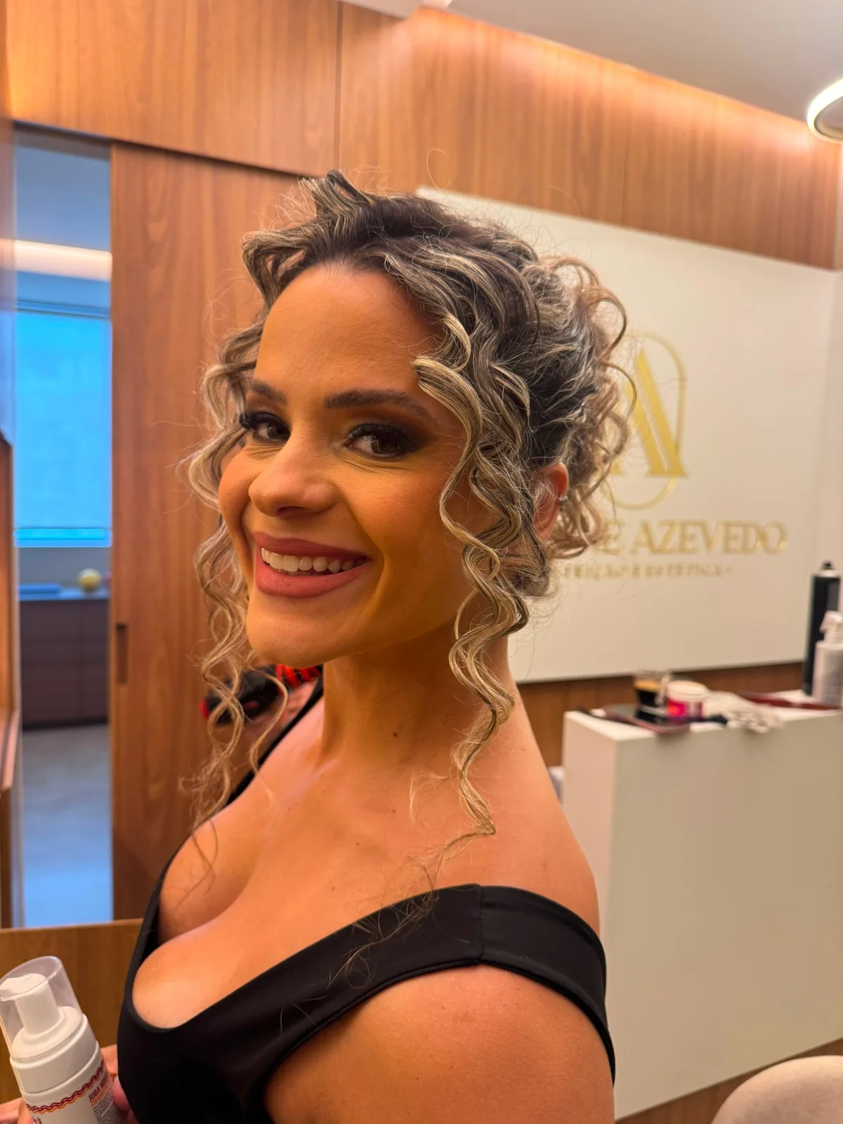 Maquiagem com acabamento sofisticado ao lado de penteado de cachos